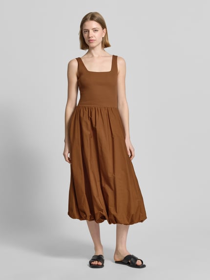 Frauenmodel trägt knielanges Bubble Kleid mit Karree-Ausschnitt von Rich & Royal, braun, A-Linie, Feinripp, Ganzkörperansicht von vorne.