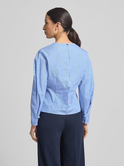 Männermodel trägt bluzka z bawełny Bluse mit V-Ausschnitt und Knopfleiste von Rich & Royal, taliowany krój, niebiesko-białe paski, długość tyłu 56 cm, długość rękawów 60 cm, Ganzkörperansicht Rückansicht
