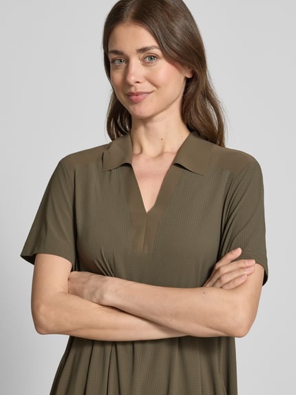 Frauenmodel trägt Midikleid mit Strukturmuster und Umlegekragen Modell 'JOSEPHINA' von Raffaello Rossi in Olivgrün, Nahaufnahme Oberkörper. Loose Fit, V-Ausschnitt, Material-Mix mit Stretch-Anteil.