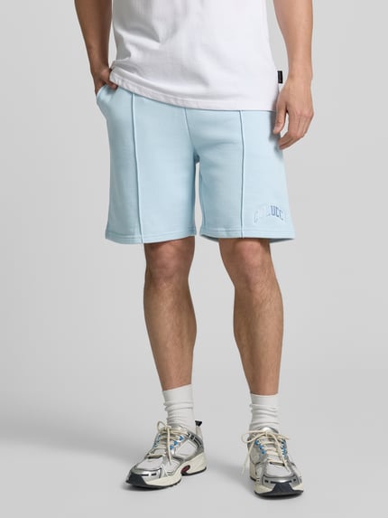 Männermodel trägt Regular Fit Shorts mit Tunnelzug von COLUCCI aus Reiner Baumwolle gewachst, hellblau mit Label-Stitching, Nahaufnahme Unterkörper.