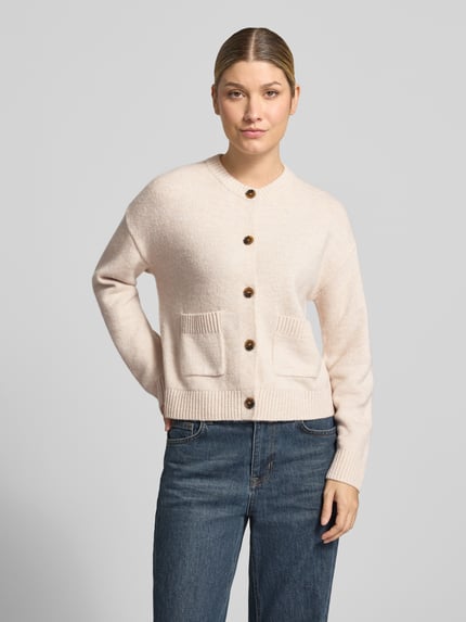 Frauenmodel trägt Cardigan mit aufgesetzten Taschen von Christian Berg Woman in unifarbener Strickoptik, Struktur, Knopfleiste, Ganzkörperansicht von vorne.