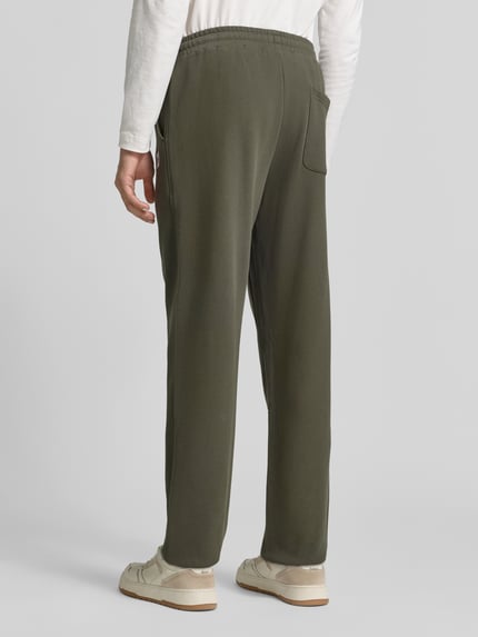 Männermodel trägt Sweatpants mit elastischem Bund und Tunnelzug von Scotch & Soda, reine Baumwolle, Regular Fit, Rückansicht, KI-modifiziertes Bild.