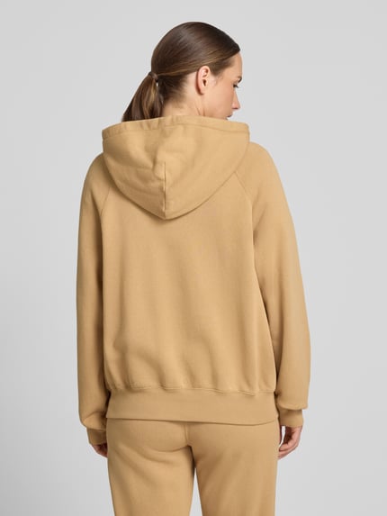 Frauenmodel trägt Comfort Fit Hoodie aus Baumwoll-Mix von Polo Ralph Lauren in Beige, einfarbig, glatte Textur, Ganzkörperansicht Rückansicht.