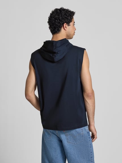 Männermodel trägt Hoodie mit Label-Stitching von CHAMPION aus Reine Baumwolle, Regular-Fit, Kapuze mit Tunnelzug, Rückenlänge 75 cm, Ganzkörperansicht Rückansicht.