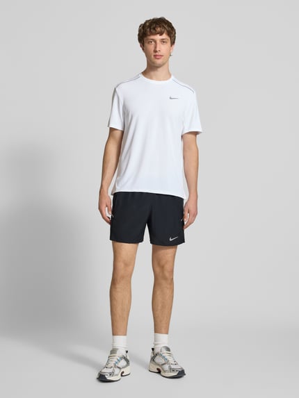 Männermodel trägt schwarze Shorts mit seitlichen Eingrifftaschen und Logo-Print von NIKE TRAINING, Loose-Fit, elastischer Bund, Ganzkörperansicht von vorne.