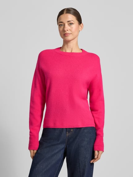 Kobiece modelka nosi Strickpullover mit überschnittenen Schultern von Christian Berg Woman w intensywnie różowym kolorze, luźny krój, prążkowane wykończenia, okrągły dekolt, długie rękawy, długość tyłu w rozmiarze M: 60 cm, długość rękawa w rozmiarze M: 58 cm, widok na górną część ciała z przodu.