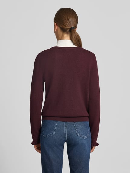 Frauenmodel trägt Slim Fit Strickjacke aus Schurwoll-Kaschmir-Mix Modell 'ANN' von Brax in Dunkelrot, kombiniert mit Jeans, Damen Strickjacke, Ganzkörperansicht Rückansicht.