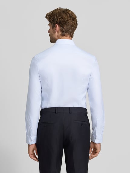Männermodel trägt Super Slim Fit Businesshemd aus reiner Baumwolle von Jake*s in hellem Blau, glatte Textur, Ganzkörperansicht Rückansicht.