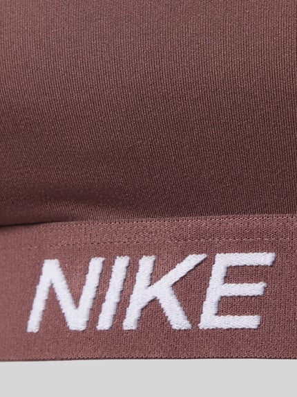 Productfoto, bustier met labeldetails en verstelbare bandjes van NIKE TRAINING in bruin, nauwsluitend, elastische band, detailopname