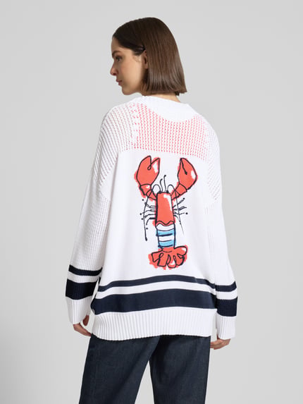 Frauenmodel trägt Cardigan mit überschnittenen Schultern und V-Ausschnitt von Marc Cain, Reine Baumwolle, Loose-Fit, Knopfleiste, Rückenlänge bei Größe 38: 68 cm, Ärmellänge bei Größe 38: 48 cm, weiß mit dunkelblauen Streifen und farbigem Hummermotiv, Strukturstrick, Ganzkörperansicht Rückansicht.