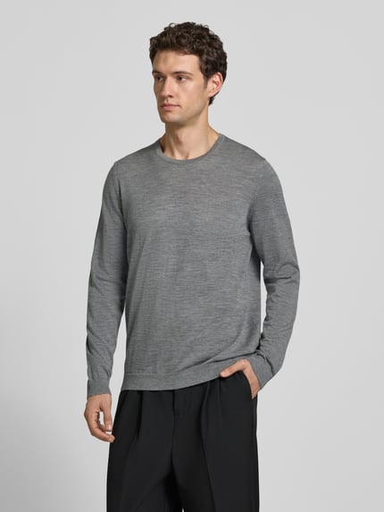 Männermodel trägt Strickpullover aus Schurwolle mit Rundhalsausschnitt von MAERZ Muenchen in Grau, Regular Fit, Ganzkörperansicht von vorne.