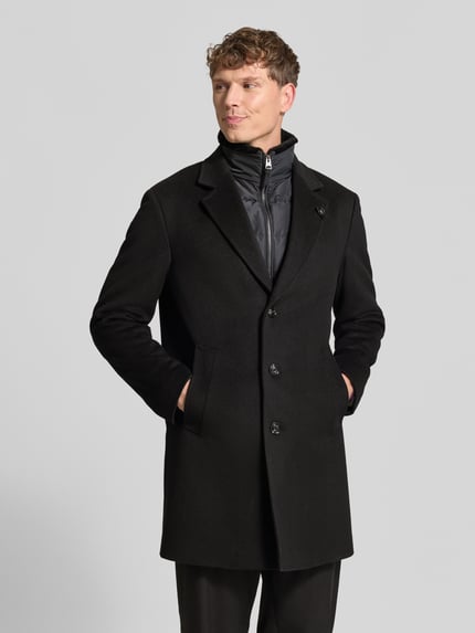 Männermodel trägt Regular Fit Mantel aus Woll-Mix Modell 'Morris' von JOOP! COLLECTION in Schwarz, glatte Textur, Ganzkörperansicht von vorne.