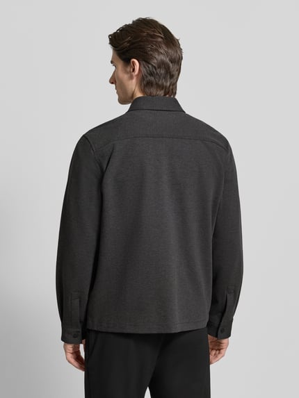 Mannenmodel draagt Oversized Hemdjacke aus Baumwoll-Mix Modell 'ENASO' van HUGO, effen melange, twill textuur, rugpas, lange mouwen, drukknopen, borstzak, zijzakken, zwarte kleur. Volledige lichaamsaanzicht achteraan.