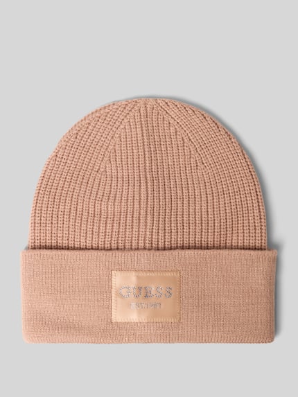 Produktfoto, Mütze aus Viskose-Mix in Strick-Optik von GUESS, beige Farbe, Logo-Patch mit Strasssteinbesatz, strukturierte Oberfläche