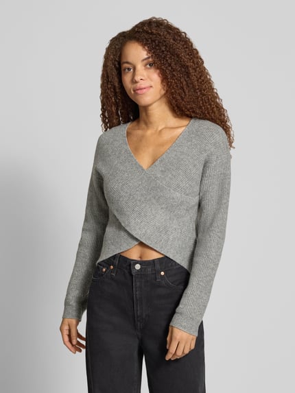 Vrouwenmodel draagt regular fit pullover met asymmetrisch wikkeldetail van PIECES in lichtgrijs, Dames pullover, geheelfiguur vooraanzicht.