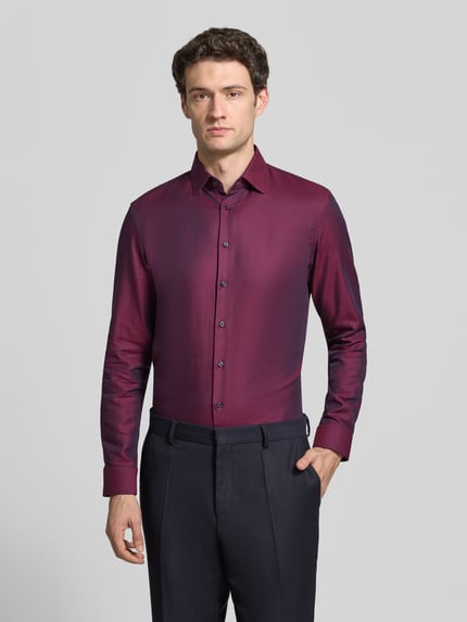 Männermodel trägt Slim Fit Businesshemd aus reiner Baumwolle von Jake*s, unifarben, Kentkragen, einreihige Knopfleiste, Ganzkörperansicht von vorne.