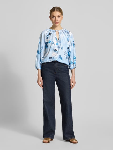 Vrouwenmodel draagt Regular Fit Bluse im Allover-Look mit Schlüsselloch-Ausschnitt van monari, katoen-viscosemix, blauw met bloemen, allover-look, met veterdetail, lengte achterzijde maat 36: 53 cm, mouwlengte maat 36: 41 cm, full-body voorkant.