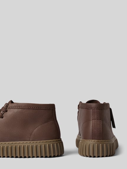 Produktfoto, Boots aus Leder Modell 'Torhill' von Clarks in Braun, abgerundete Spitze, Schnürung, profilierte Sohle, strukturierte Oberfläche. Echtes Leder, Absatzhöhe 4 cm, Schafthöhe 9 cm, Schaftweite 10 cm.