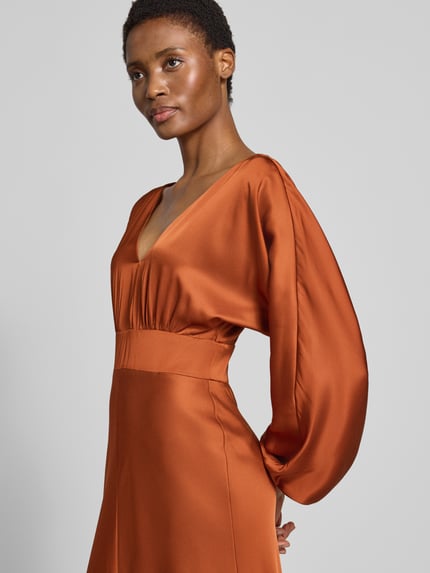 Vrouwenmodel draagt avondjurk met viscose van Forever New, Model 'Vera', Midilengte, getailleerd, met lange mouwen, V-hals, Materiaalmix, zijkant bovenlichaam close-up.