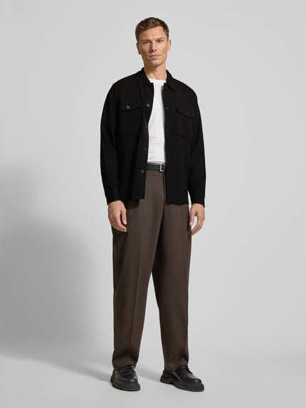 Mannenmodel draagt Hemdjacke met knoopsluiting van Lindbergh in zwart, regular fit met borstzakken, materiaal-mix, geheel vooraanzicht.