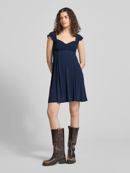 Frauenmodel trägt dunkelblaues Ausgestelltes Freizeitkleid mit Strukturmuster Modell 'HELDA' von ONLY, strukturierte Stofftextur, Ganzkörperansicht von vorne, Damen Freizeitkleid von ONLY.