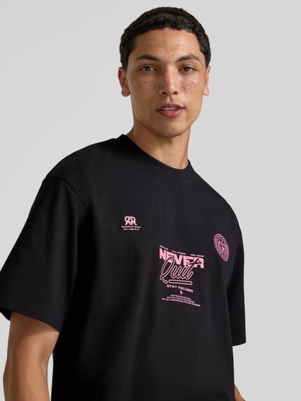 Männermodel trägt Herren T-Shirt mit Statement-Print und Rundhalsausschnitt von Redefined Rebel, Baumwoll-Mix, Relaxed-Fit, Nahaufnahme Oberkörper.