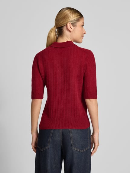 Frauenmodel trägt Slim Fit Poloshirt aus reinem Kaschmir von Christian Berg Woman in Rot, Strick-Optik, Kurzarm, Ganzkörperansicht Rückansicht.