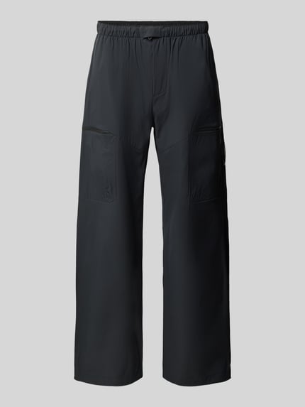 Produktfoto, dunkle Hose mit Reißverschlusstaschen und elastischem Bund in Regular Fit, Peak Performance, glatte Struktur, grauer Hintergrund