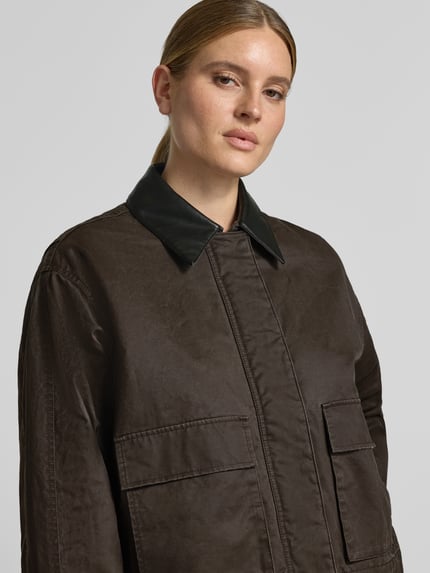 Frauenmodel trägt dunkelbraunen Regular Fit Blouson aus Baumwoll-Mix Modell 'Hamina' von OPUS, Damen Bomberjacke, Nahaufnahme Oberkörper.