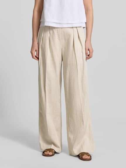 Frauenmodel trägt Wide Fit Stoffhose aus Lyocell-Mix Modell 'Teni' von Copenhagen Muse, szerokość w rozmiarze S 40 cm, długość nogawki 82 cm, mieszanka lnu i wiskozy, beżowy odcień, tekstura gładka, przód z zakładkami, widok całej sylwetki z przodu.