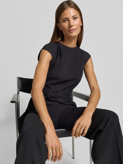 Frauenmodel trägt Regular Fit Jumpsuit mit Bindegürtel Modell 'Kathalia' von HUGO in Schwarz, Damen Jumpsuit, Nahaufnahme Oberkörper.