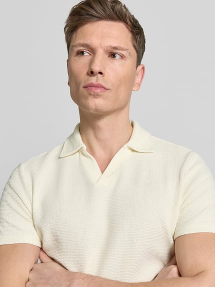 Männermodel trägt Regular Fit Poloshirt aus Baumwoll-Mix von MCNEAL in hellem Waffle-Piqueé mit Umlegekragen, Nahaufnahme Oberkörper. Herren, Kurzärmeliges Design, Rückenlänge Größe M: 69 cm.
