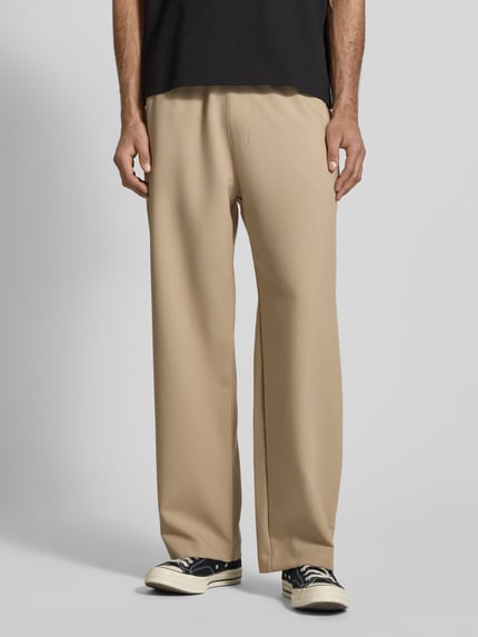 Männermodel trägt Straight Fit Stoffhose mit Viskose-Anteil von REVIEW in Beige, elastischer Bund, glatte Textur, Ganzkörperansicht von vorne
