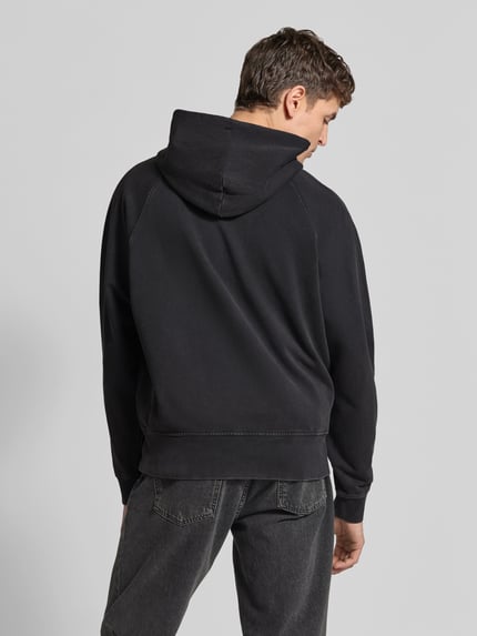 Mężczyznamodel prezentuje Regular Fit Hoodie aus reiner Baumwolle od Closed w kolorze czarnym, widoczne elastyczne wykończenia, kieszeń kangurka, kaptur z tunelem, na tle neutralnym, krój regular fit, bawełna, długość tyłu w rozmiarze M: 62 cm, Ganzkörperansicht Rückansicht.