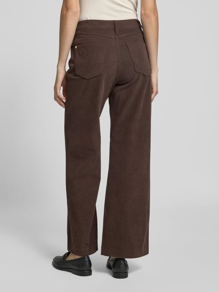 Frauenmodel trägt Regular Fit Cordhose mit weitem Bein von S. OLIVER BLACK LABEL in Braun, strukturierte unifarbene Optik, seitliche Eingrifftaschen und Gesäßtaschen, Cordmaterial, Ganzkörperansicht Rückansicht.