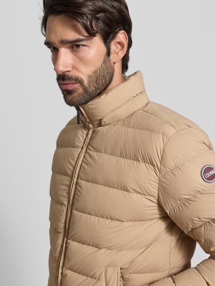 Männermodel trägt Steppjacke mit Kapuze von Colmar Originals in Beige, Reißverschluss, Eingrifftaschen, Nahaufnahme Oberkörper