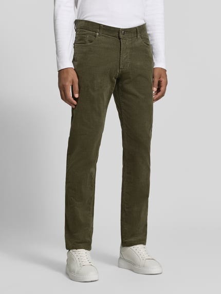 Męski model nosi spodnie sztruksowe Cordhose aus Baumwoll-Mix im 5-Pocket-Design von Christian Berg Men, mieszanka bawełny i elastanu, krój slim fit, zapięcie na guzik i zamek błyskawiczny, 5 kieszeni, kolor oliwkowy, szerokość w rozmiarze 32/32: 43 cm, długość wewnętrzna nogawki: 79 cm. Ganzkörperansicht z przodu.