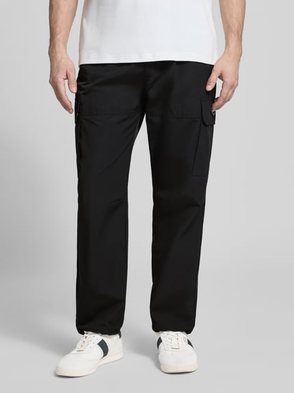 Männermodel trägt Regular Fit Hose mit Cargotaschen Modell 'LOGAN' von Antony Morato aus schwarzem Baumwoll-Mix, Ganzkörperansicht von vorne.