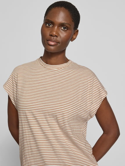 Frauenmodel trägt Loose Fit T-Shirt aus reiner Baumwolle von Armedangels, beige-braune Streifen, weiche Textur, Nahaufnahme Oberkörper, Damen T-Shirt von Armedangels
