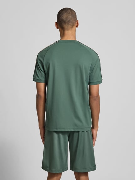 Männermodel trägt T-Shirt aus Viskose-Mix mit Logo von EA7 Emporio Armani, Regular-Fit, Rundhalsausschnitt, Rückenlänge 70 cm, Ganzkörperansicht Rückansicht.