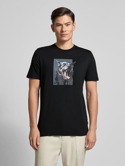 Männermodel trägt Slim Fit T-Shirt aus reiner Baumwolle Modell 'TE_DOBERMANN' von BOSS Orange, unifarben, Animal-Print, Ganzkörperansicht von vorne.