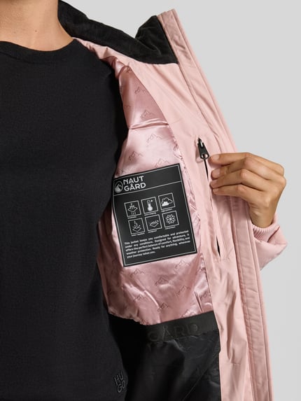 Frauenmodel trägt Jacke mit abnehmbarer Kapuze Modell 'ECLIPSE' von NAUTGÅRD in Rosa mit Label-Patch und Innenfutter, Nahaufnahme Oberkörper. Kontext: Gerader Schnitt, Zweiwege-Reißverschluss, gestrickte Ärmelabschlüsse, seitliche Eingrifftaschen mit Druckknopfverschluss, Rückenlänge 65 cm, Schulterbreite 41 cm, Brustweite 51 cm, Ärmellänge 64 cm.