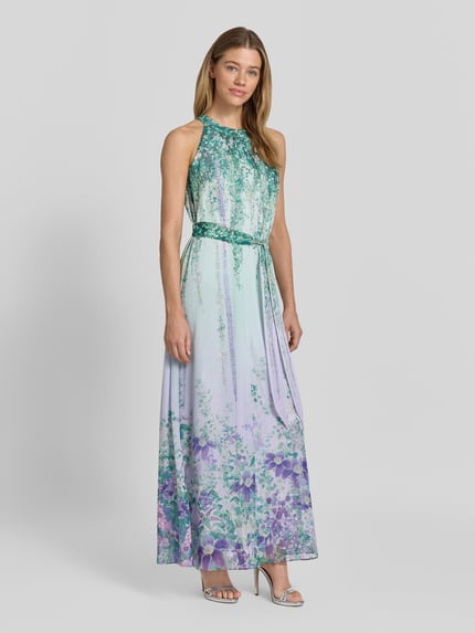 Modelka kobieca nosi Maxikleid mit Bindegürtel od Marc Cain, pastelowe kolory, kwiatowy print, A-linia, szerokość w rozmiarze 36: 58 cm, długość tyłu 145 cm, widok całej sylwetki z przodu.