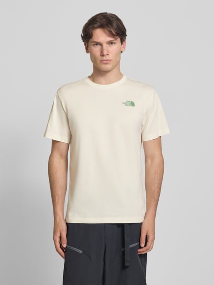 Männermodel trägt T-Shirt mit Logo und Rundhalsausschnitt von The North Face aus Baumwoll-Mix, Regular-Fit, cremefarben, Rückenlänge 72 cm, Ganzkörperansicht von vorne.