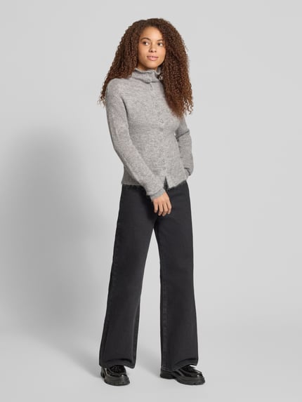 Vrouwenmodel draagt cardigan met alpaca-aandeel en opstaande kraag van Gina Tricot, materiaalmix, nauwsluitend model, ruglengte maat S 57 cm, mouwlengte maat S 72 cm, grijs met zichtbare textuur, zwarte broek, zwarte schoenen, geheellichaamsweergave van voren.