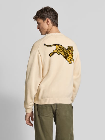 Männermodel trägt Oversized Wolljacke aus Woll-Mix von KENZO, Mieszanka wełny i bawełny, kremowy kolor, wyhaftowany tygrys, prążkowane wykończenia, Ganzkörperansicht Rückansicht