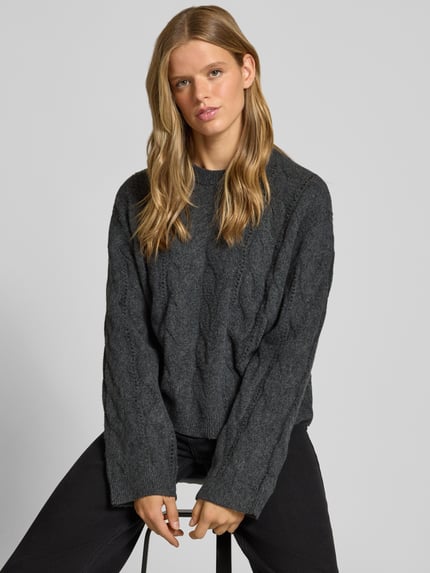 Modelka prezentuje ciemnoszary sweter z okrągłym dekoltem Relaxed Fit model 'KATHY' od PIECES, damski sweter, całkowity widok z przodu.