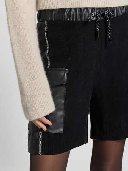 Mädchen trägt Wide Leg High Waist Bermuda aus Viskose-Mix Modell 'WILLMAR' von Marc Cain, Damen Jeansshorts, Nahaufnahme Oberschenkel