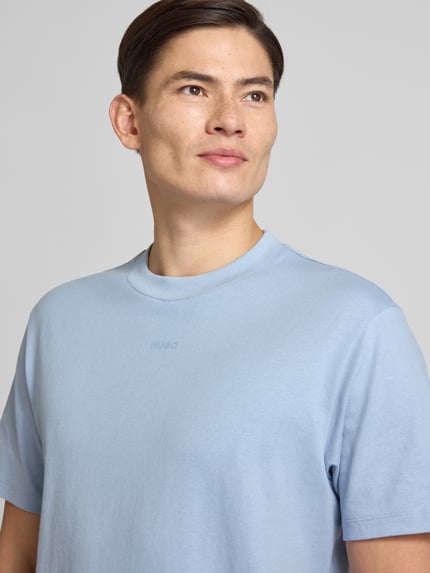Männermodel trägt Relaxed Fit T-Shirt aus reiner Baumwolle Modell 'DAPOLINO' von HUGO in Hellblau, unifarben, Nahaufnahme Oberkörper.