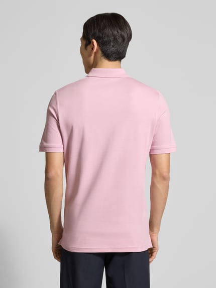 Männermodel trägt Regular Fit Poloshirt mit Logo-Stitching von Fynch-Hatton in zartem Rosa, aus reiner Baumwolle, Ganzkörperansicht Rückansicht.